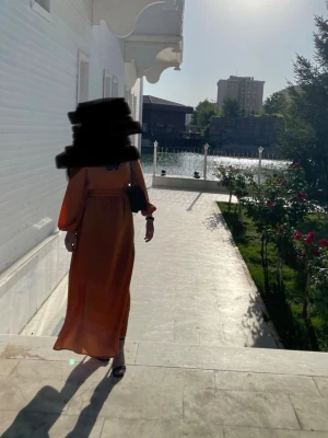 Lång mörk orange omlottklänning med lös bälte - Snygg långklänning i varm orangr ton med omlottmodell och markerad midja med bälte. Klänningen har långa puffärmar med resår vid handlederna och ett elegant fall. Perfekt för dig som vill ha en stilren och trendig look.