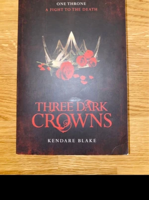 Three Dark Crowns av Kendare Blake - En spännande fantasybok på engelska, 'Three Dark Crowns' av Kendare Blake. Boken handlar om tre systrar med magiska krafter som slåss om tronen på ön Fennbirn. Perfekt för dig som gillar mörk fantasy.