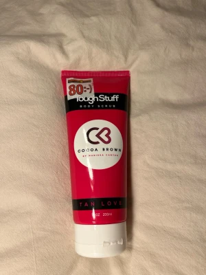 Cocoa Brown Tough Stuff Body Scrub - Cocoa Brown Tough Stuff Body Scrub är en kroppsskrubb i en rosa och vit tub på 200 ml. Produkten är framtagen av Marissa Carter och har en praktisk skruvkork. Perfekt för att exfoliera huden inför brun utan sol. DEN ÄR HELT OANVÄND!!
