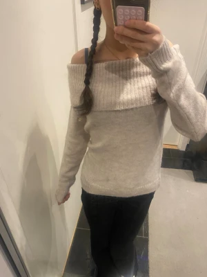 Beige off-shoulder stickad tröja från gina tricot young - Säljer en beige stickad tröja med bred ribbad off-shoulder krage. Tröjan har lång ärm och är gjord i mjukt material som ger en avslappnad och trendig look. Använts en gång💕
