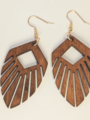 Ultralätta Bruna träörhängen med geometrisk design retro - Eleganta örhängen med en kombination av trä och naturmotiv.  Perfekt för att komplettera din stil med en naturlig och bohemisk touch.  Trädelen är ca 5 cm lång. Motivet är fäst på högkvalitativa örhänges-krokar i rostfritt stål.  Nya med etikett.