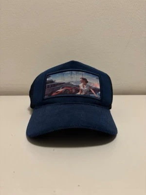 Mörkblå truckerkeps med tryck - Snygg mörkblå keps från revenite. Säljer den för jag aldrig använder den.                                                Kan sälja den för mindre vid snabb affär!