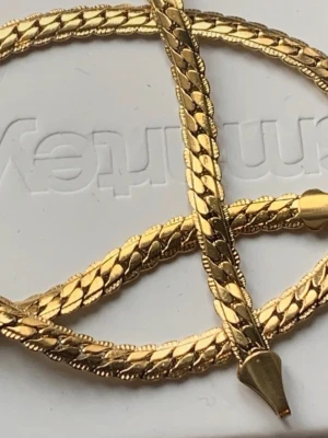 Guldpläterat halsband från Luce  - Säljer ett chunky guldpläterat halsband med flätad kedja och snygga detaljer. Halsbandet har en exklusiv känsla och är perfekt för dig som vill sticka ut med ett statement-smycke. Klassisk design med elegant finish.