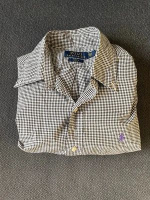 Ralph Lauren Skjorta - Rutig långärmad Ralph Lauren skjorta i storlek 37 (S). Skjortan har i stort sett aldrig använts och är därmed i toppskick (som ny). Nypris ligger på ca 1300kr. 