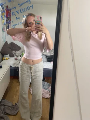 Roxy lågmidjade linnebyxor - Säljer ett par beiga linnebyxor från roxy ‼️Äkta‼️ med breda ben och dragsko i midjan. Byxorna har en avslappnad passform och är tillverkade i ett lätt linnematerial som är perfekt för varma dagar. Passar dig som gillar en chill och stilren look.