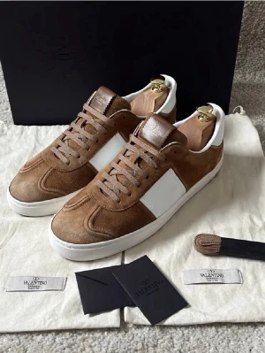 Valentino Fly Crews - Hej! Säljer dessa riktigt snygga Valentino Garavani skor i den populära modellen Flycrew i guldbrun färg! Mycket fint skick in och utvändigt endast att mockan är lite smått sliten därfram men går säkert att borsta upp 😊 passar till mycket, normal i storleken, smått slipad sula och riktigt stilrena! 13/22 nitar kvar, kan köpas äkta extranitar för 100kr st! Skriv jättegärna vid intresse av köp samt detaljbilder, mått eller frågor! 🤗