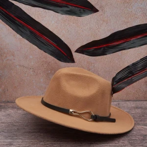 Kamelbrun fedora med svart band Cowboyhatt - Snygg kamelbrun fedora med brett brätte och svart band runt kronan. Bandet har en guldfärgad metallspänne som detalj. Hatten är tillverkad i filtmaterial och har en klassisk, stilren form som passar till många looks.