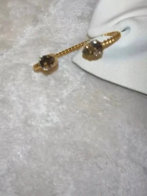 Guldfärgat armband Caroline Svedbom - Snyggt guldfärgat armband från Caroline Svedbom med tvinnad design och två dekorativa ändar. Armbandet är öppet och har en stilren, modern look som passar perfekt till din outfit. Tillverkat i metall med exklusiv känsla.