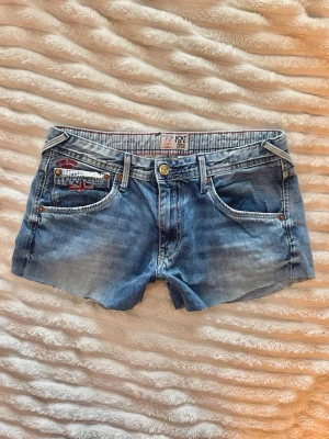 Lågmidjade Pepe jeans shorts - Säljes ett par lågmidjade Pepe Jeans shorts😍!  De har massa fina detaljer för en lite vintage look. Storleken säger 16 elelr 176, vilket är barnstorlek. Jag skulle anse att storlek är 36/S eller kanske XS. De är för små för mig, därav inga bilder på.  Midjemått: 38cm (rakt över)  Lårbredd: 28cm (rakt över)