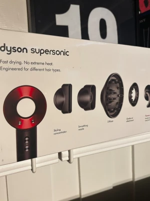 Dyson Supersonic hårfön röd - Säljer en Dyson Supersonic hårfön i röd och svart med fem olika stylingmunstycken. Hårfönen är designad för snabb torkning utan extrem värme och passar alla hårtyper. Levereras i originalförpackning med stylingkoncentrator, smoothing nozzle, diffuser och andra tillbehör.