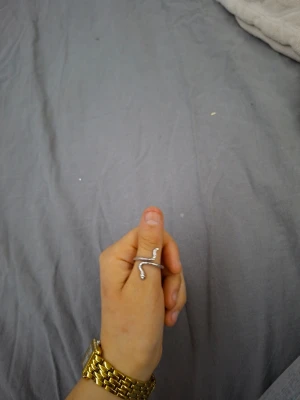 6 st silvriga ormringar - Säljer 6 st jätte fina och coola silver färgade ringar i olika former av ormar som slingrar sig runt fingret. Aldrig använd eftersom använder guld och inte silver men råkade köpa silver.