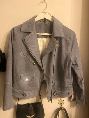 Ljusgrå/blå mockajacka med dragkedjor - Perfekt för en stilren och snygg look 