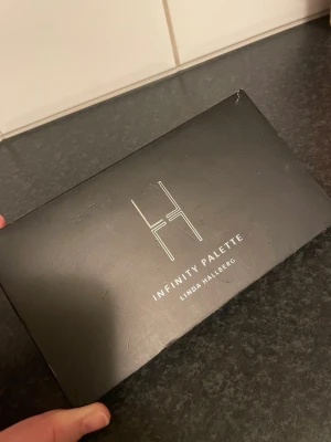 Infinity Palette från Linda Hallberg - Snygg ögonskuggspalett från Linda Hallberg med åtta nyanser i neutrala, varma och skimrande toner. Paletten har både matta och skimriga färger som beige, guld, korall, brun och svart. Kommer i en stilren svart förpackning med spegel. Nypris 500