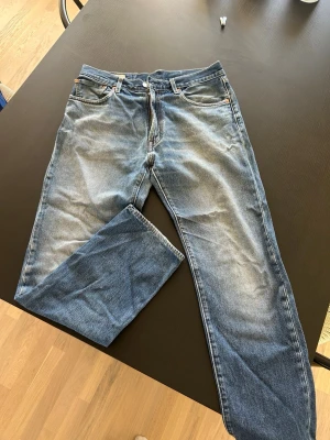 Blå Levi’s jeans  - Säljer ett par klassiska blå jeans med rak passform och snygg tvätt. Jeansen har fem fickor, dragkedjegylf. Modell 551Z
