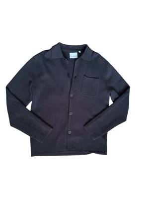 Bläck overshirt - Stilren svart overshirt från Black med klassisk krage, knäppning framtill och en bröstficka. Tillverkad i ett mjukt, stickat material som ger en avslappnad men ändå uppklädd look. Perfekt att bära över en t-shirt eller skjorta.