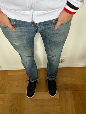 Dondup George jeans - Trendiga Dondup jeans i klassisk blå tvätt med diskreta slitningar som ger en fräsch, stilren look. Jeansen har en snygg passform och passar både till vardag och mer uppklädda outfits. I mycket gott skick utan defekter. Hör gärna av dig vid frågor!