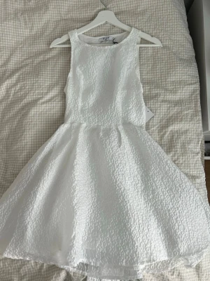 Studentklänning  - Säljer denna fina vita klänning från Nakd. Aldrig använd med prislappen kvar 