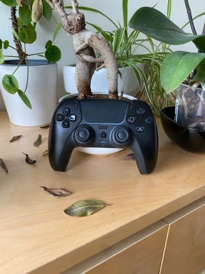 Svart trådlös handkontroll P4-Plus - Säljer en svart trådlös handkontroll, modell T28 från P4-Plus. Kontrollern har klassisk PlayStation-layout med dubbla styrspakar, styrkors och knappar. Ergonomisk form och tillverkad i plast. Passar till PS4 och har modern design och passar till ps5.