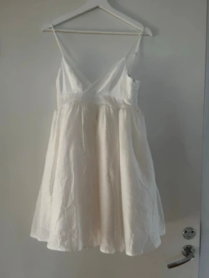 Studentklänning  - Söt vit kortklänning med v-ringning och tunna axelband💕klänningen är i bomull med två enkla underkjolar för att ge struktur💕 perfekt klänning för studenten