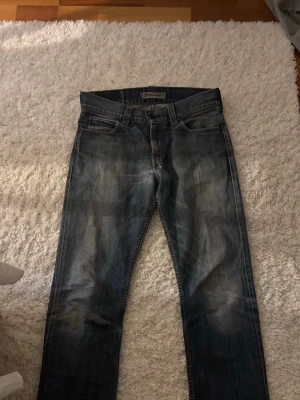Levis 506 jeans  - Levis 506 jeans i urtvättad blå/mörkblå färg. Passformen är straight/bootcut och lite mindre i midjan än vad man tror. Har ett lagat hål baktill med insydd lapp på insidan, har också mindre slitningar vid anklarna. 
