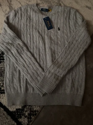 Polo ralph laurent tröja - En grå aldrig använd stickad tröja från polo ralph laurent. Tröjan går för 2000 på zalando 
