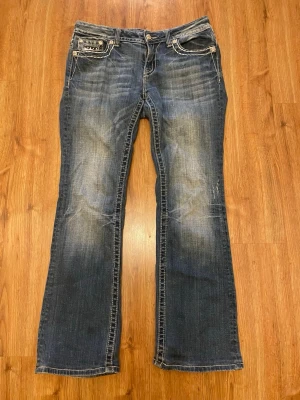 Mörkblå jeans från Miss Me - Snygga mörkblå bootcut jeans från Miss Me. Bra skick förutom att det är klippt i innersömmen vid knappen, det är draget ett snöre där då de varit förstora i midjan för mig. Inget som syns och snöret kan dras ur (syns på bilden). 84 cm midjemått, 76 cm innerbenslängd ⭐️