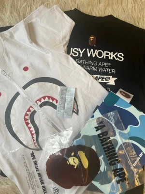 BAPE t-shirt svart och vit - Båda T-skjortor har köpt från Bape Store in Tokyo så producterna är authentic båda! Säljer en svart t-shirt från A Bathing Ape med den klassiska lilla ap-loggan broderad på bröstet. T-shirten har rund hals och är tillverkad i mjuk bomull. Perfekt för dig som gillar streetwear och vill ha en clean look.