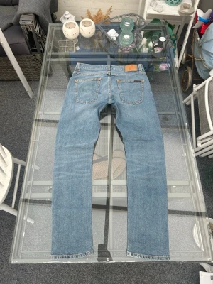 Nudie Jeans Lean Dean – Ljusblå – W30 L30 – Mycket bra skick - Säljer ett par snygga Nudie Jeans Lean Dean i ljusblå tvätt. Klassisk slim fit med stretch som sitter riktigt bra.  • Storlek: W30 L30 • Passform: Slim fit • Material: 98% bomull, 2% elastan • Färg: Ljusblå denim • Skick: Mycket bra skick  Jeansen är gjorda i ekologisk bomull och har den klassiska Nudie-looken med fina slitningar. Perfekta till både vardag och mer uppklätt.  Hör av dig vid frågor eller om du vill ha fler bilder 👍