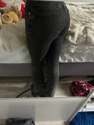 Svarta bootcut jeans med tvättad look - Säljer ett par svarta bootcut jeans i grå och mid/låg midja. Helt ok skick. Väldigt slitna längst ner därav pris🫰🫰