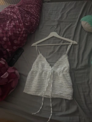 Vit linnetopp med knytband - Säljer ett sött vit linne då det är lite för litet för mig de är stolek xs/s 💕, typ aldrig använd och i super skick. Men vet dock inte vart den är ifrån 💕