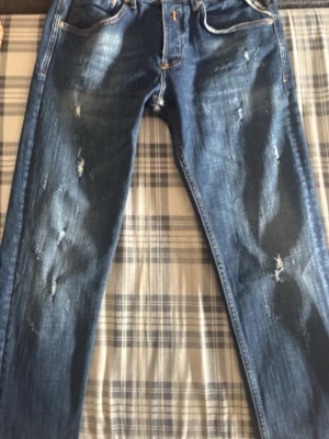 Blå slitna jeans med broderad ficka - Säljer ett par helt nya replay  jeans med slitningar, ( Oanvända )