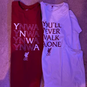 Liverpool FC t-shirts YNWA - Två t-shirts från Liverpool FC, en i rött och en i vitt. Båda har trycket 'YNWA' eller 'You'll Never Walk Alone' framtill och klubbens logga. Klassisk rund hals och korta ärmar. Perfekt för dig som älskar fotboll och vill visa ditt stöd för laget.               Strl: s passar även M.                Köp båda för 400, men om du bara vill ha en så kostar de 250. Skicket är helt nytt, har aldrig använt dem så de är väldigt bra pris. 