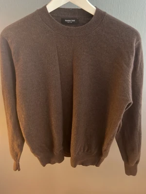 Brun Kashmir tröja Massimo Dutti - Mjuk brun Kashmir tröja från Massimo Dutti med rund halsringning och ribbade muddar vid ärmslut och nederkant. Enkel och stilren design som passar perfekt till lager på lager. Tillverkad i ett skönt material som känns lyxigt mot huden.