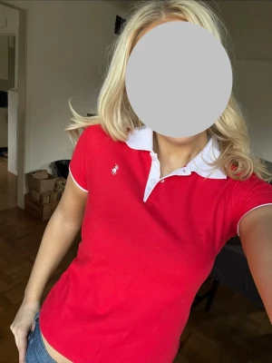 Röd polo t-shirt från Polo Ralph Lauren vintage - Snygg röd polo t-shirt från Polo Ralph Lauren med vit krage och korta ärmar. Ikonisk logga broderad på bröstet. Klassisk passform och tillverkad i mjuk bomull. Perfekt för dig som vill ha en stilren och sportig look.