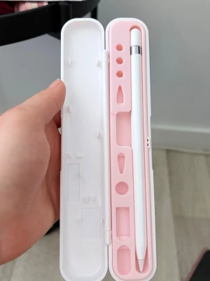Apple Pencil med rosa fodral - Apple Pencil i vit färg med en stilren och minimalistisk design. Pennan kommer med ett hårt fodral i vitt och rosa plast som har plats för tillbehör. Perfekt för digitalt skapande och anteckningar på iPad.