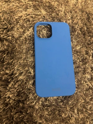 Blått mobilskal i silikon iPhone 12 - Snyggt blått mobilskal från Apple i mjukt silikonmaterial. Skalet har en stilren design med rundade hörn och ett stort kamerauttag. Perfekt för dig som vill ha ett enkelt men färgglatt skydd till din mobil.
