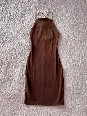 H&M - ribbed halterneck dress - Brun ribbad klänning från H&M-divided i "bodycon"-modell, storlek XS. Klänningen har smala axelband och en halterneck-skärning som markerar axlarna och ryggen fint.  Helt oanvänd i nytt skick!