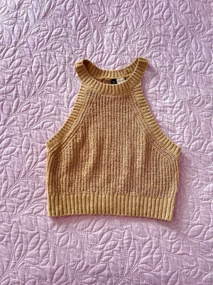 H&M - stickad halterneck-topp - En beige stickad halterneck crop-top med beach-vibe från H&M i modell ”Stickad Tanktopp”, storlek S.