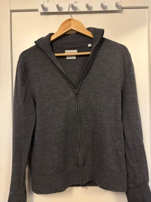 Grå stickad kofta med dragkedja - Mysig grå stickad kofta från Bread & Boxers med hel dragkedja framtill och hög krage. Perfekt för lager på lager och enkel att matcha med olika outfits. Långärmad modell i mjukt material som känns skönt mot huden.🔥🙌