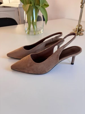 Beige bruna mocka klackar - Säljer dessa aaasss snygga klackarna som tyvärr inte har kommit till användning. Jättesnygga stilrena och eleganta. Perfekt färg nu till sommaren och jätte bekväma att gå i💘vet ej vart dom är ifrån då det var år sedan jag köpte dom men förmodligen Zara eller hm eller något sådant💘