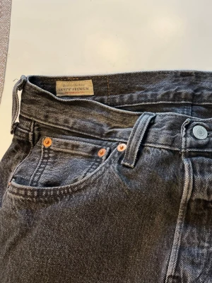 Levi's 501 svarta jeans 29/32 - Klassiska svarta Levi's 501 jeans i rak modell med knappgylf och fem fickor. Jeansen har tydliga kontrastsömmar och den ikoniska läderpatchen bak i midjan. Tillverkade i slitstark bomullsdenim och har den röda Levi's-taggen på bakfickan. Köptes för 1300kr (: