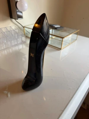 Good Girl parfym från Carolina Herrera - BUDA GÄRNA Snygg parfymflaska från Carolina Herrera i form av en högklackad sko. Flaskan är svart med gulddetaljer och har en elegant, modern design som verkligen sticker ut på parfymhyllan. Perfekt för dig som gillar lyxiga och unika dofter.