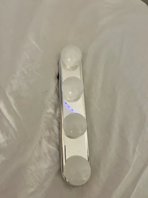 Lampa - perfekt för sminkning. Lampan har sugproppar på baksidan för enkel montering på släta ytor eller så kan man skruva fast den på väggen. Ljuset är lite mer åt de kalla/neutrala hållet. Man lägger in batterier där bak.