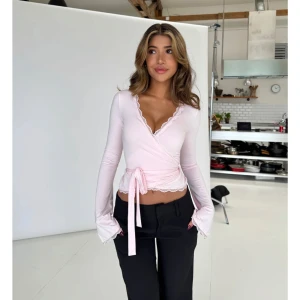 Ljusrosa omlottopp Venderby’s - Supersöt ljusrosa omlottopp med långa utsvängda ärmar och v-ringning. Från Venderby’s. Endast testad, så i nyskick. I storlek S/M.