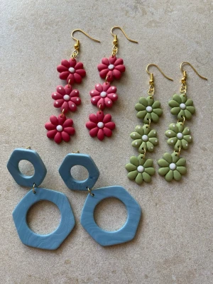 3 par handgjorda örhängen – set med variation - 3 par handgjorda örhängen i polymerlera  Ett set med både blomdesign och geometriska former.  Blommor: ca 8 cm Blå: ca 6 cm  Perfekt om du vill ha variation i både färg och form.   Alla par är handgjorda och unika.  Antiallergiska detaljer Lätta Skickas  Säljs även separat i andra annonser