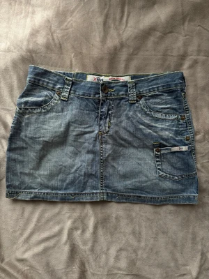 Lågmidjad Vintage Jeanskjol - Snygg vintage jeanskjol med lågmidjad passform 💕 Midjemått: ca 40cm Längd: ca 33cm Nederkant: ca 49cm  Alla bud över 200kr accepteras - säg till om du har några frågor :D  002   #vintage #y2k #jeanskjol #sommar #vintagedenim #denim #secondhand #preloved #lowrise #y2kvintage #miniskirt #minikjol