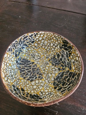 Skål av kokosnöt med mosaikmönster - Unik skål tillverkad av kokosnöt med insida dekorerad i svart, vitt och guldigt mosaikmönster. Utsidan har naturlig kokosnötsyta. Perfekt som dekoration eller för småprylar.