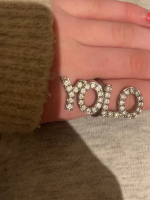 IOAKU ring - silvrig ”Yolo” ring med små diamanter från ioaku, färgen har börjat försvinna lite vid själva ringen men inte på ordet, ganska bra skick.