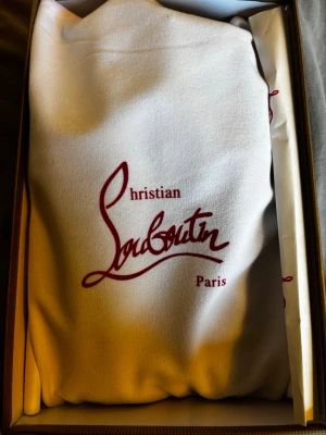 Christian Louboutin marinblåa skor - Snygga marinblåa skor  från Christian Louboutin i mocka med klassisk röd sula och svarta skosnören.