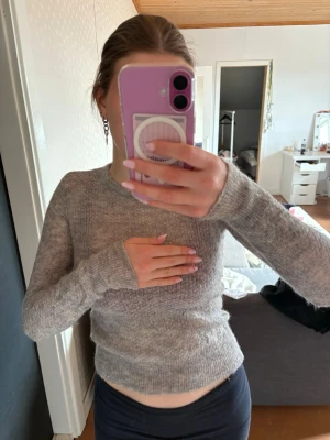 Ljusgrå stickad tröja - Den har långa ärmar vilket är så skönt! Snyggt att den sitter lite tightare vid midjan och handlederna också. Xs men sitter som S också